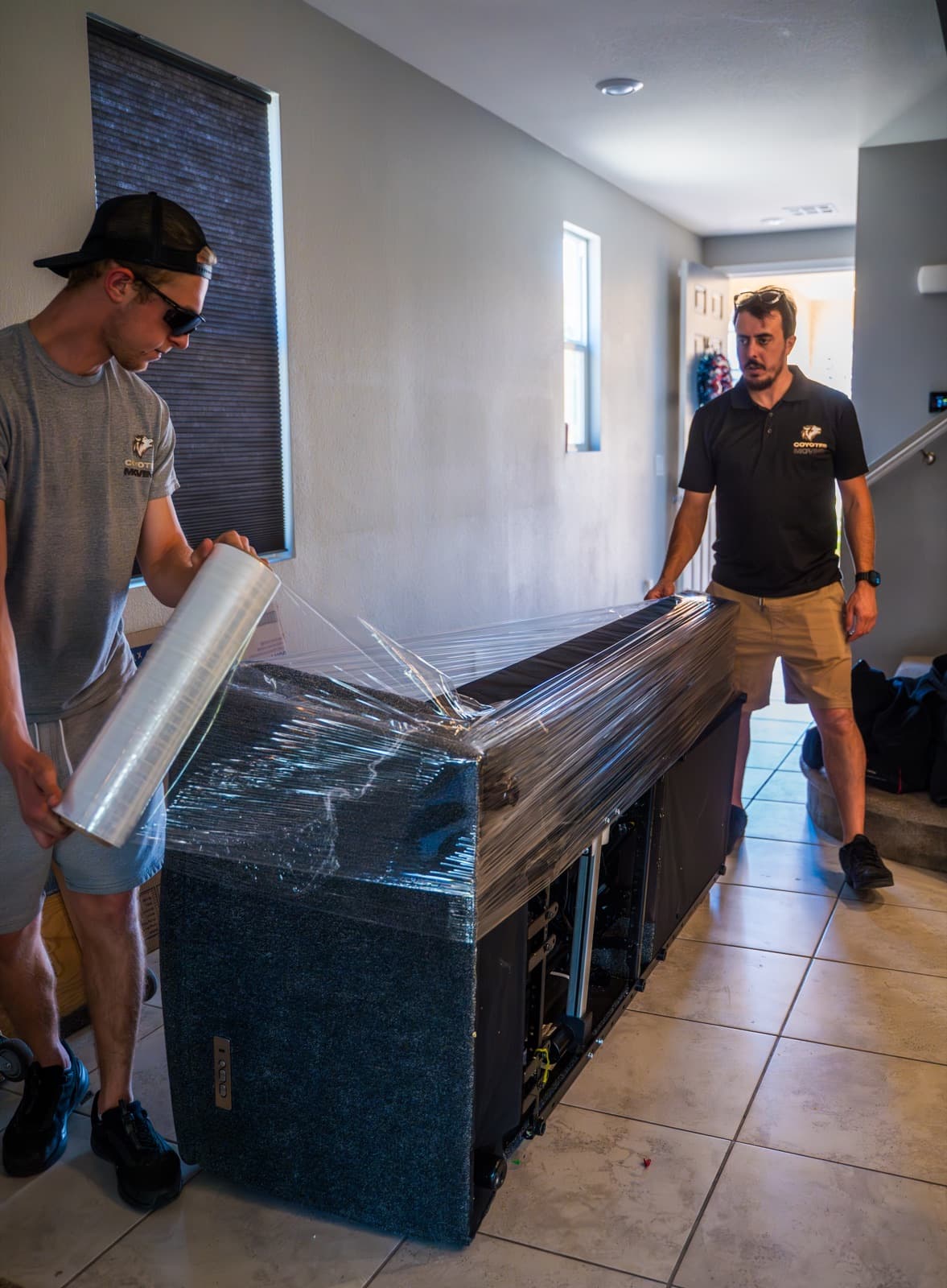 Coyotes Moving crew carrying furniture up stairs at an apartment complex