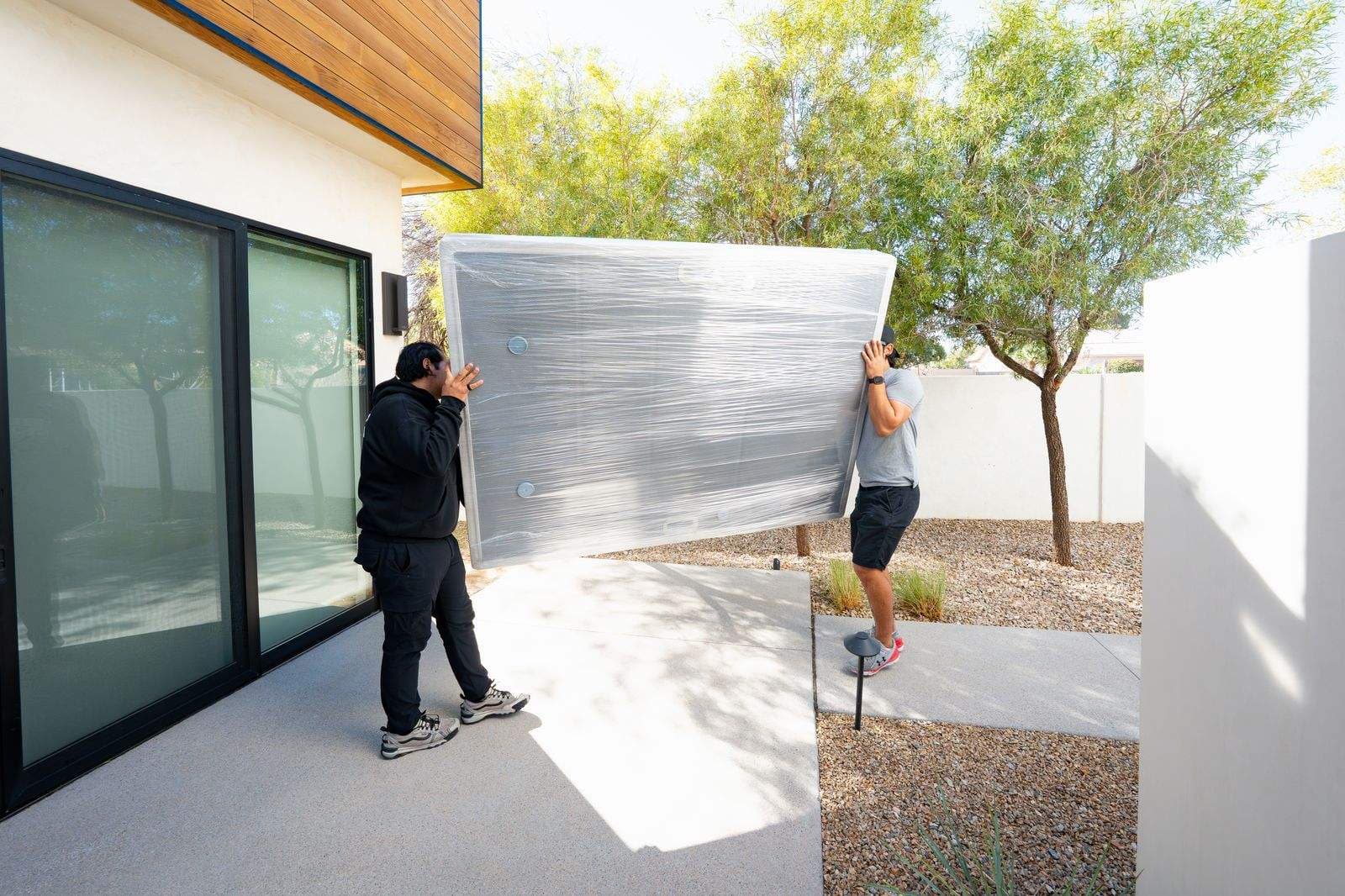 Coyotes Moving crew carrying furniture during a Las Vegas local move, one of the factors that affects the final cost